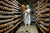 Elena at work, controlling the ripening process. Cheese shop, Formatgeria Mas d´Eroles, artisan cheese making, Adrall village, Alt Urgell, Lleida, Catalonia, Spain