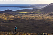 Frau beobachtet die Lavafelder am Vulkan Fagradalsfjall, Halbinsel Reykjanes, Sudurland, Island, Nordeuropa