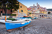 Blick auf die bunte Stadt Cervo und das Boot am Strand. Cervo, Provinz Imperia, Riviera di Ponente, Ligurien, Italien, Europa.