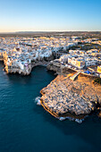 Aerial view of the overhanging houses of Polignano a Mare at sunrise. Bari district, Apulia, Italy, Europe.