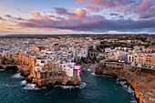 Aerial view of the overhanging houses of Polignano a Mare at sunrise. Bari district, Apulia, Italy, Europe.