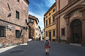Ein junges Mädchen läuft durch die Straßen von Siena, Toskana, Italien, Europa