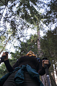 Ein junges Mädchen, das in den Wipfeln der Bäume nach Tieren Ausschau hält, Rabbi, Rabbital, Autonome Provinz Trient, Trentino Alto-Adige/Südtirol, Italien