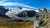Trekkers admire Rutor glacier, close to Deffeyes refuge,Rutor, Vedette and Grand Assaly summit on background, La Thuile valley, Aosta Valley, Italy, Europe