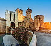 Scaligerschloss von Sirmione, Eingang bei Sonnenaufgang mit Tourist, Gardasee, Sirmione, Provinz Brescia, Italien, Norditalien, Europa, Südeuropa