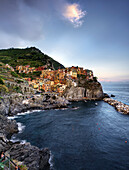 Panoramic photo of Manarola with a view of the harbor and rocky beach, during the late afternoon , Manarola, La Spezia, Cinque Terre, Italy, Europe, South Europe