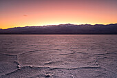 The sun is setting over Badwater Basin in the Death Valley National Park, California, USA