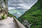Pathway del ponale, mit einem Blick auf den Gardasee, Touristen, die zu Fuß und Berg im Hintergrund Riva del Garda, Provinz Trient, Trentino alto adige, Italien, Europa.