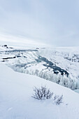 Europa, Island: ein Wintersturm zieht über den Gullfoss Wasserfall, eine Ikone der Golden Circle Route