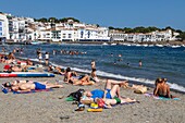 Tanning and swimming on a small beach in the town, cadaques, costa brava, catalonia, spain