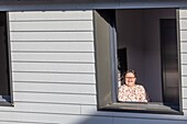 Bewohnerin am Fenster ihres Einzelzimmers, Pflegeheim für Erwachsene mit geistiger Behinderung, residence la charentonne, adapei27, association departementale d'amis et de parents, bernay, eure, normandie, frankreich