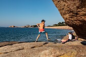 Kinder auf den Felsen, Kieselstrand von Toul Drez, renote Inselspitze, Tregastel, rosa Granitküste, cotes-d'armor, Bretagne, Frankreich
