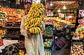 Vendor with his bunch of bananas, fruit and vegetable stand, el dahar market, popular quarter in the old city, hurghada, egypt, africa