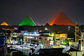 Hotel terrace and the city's popular quarter lit up for the sound and light show on the pyramids of giza, cairo, egypt, africa