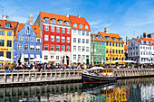 View of the colourful buildings and an old ship along Nyhavn canal with reflection in the water, Copenhagen, Hovedstaden Denmark, Europe