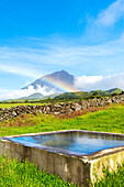 Mount pico and its reflection in the water with rainbow, Lajes do Pico municipality, Pico island (Ilha do Pico), Azores archipelago, Portugal, Europe