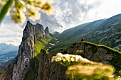 Hiker man on mountain ridge admiring Saxer Lucke mountain, Appenzell Canton, Alpstein Range, Switzerland