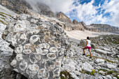 Frau genießt die Wanderung im geologischen Fossiliengebiet Orti della Regina, Brenta-Dolomiten, Madonna di Campiglio, Trentino, Italien