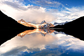 Sunset over mountains mirrored in the clear water of Bachalpsee lake, Grindelwald, Bernese Oberland, Bern Canton, Switzerland
