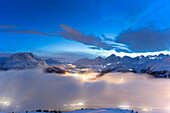 Nächtlicher Nebel über den Oberengadiner Bergen während des schneereichen Winters, Muottas Muragl, Kanton Graubünden, Schweiz