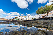 Weiß getünchte Gebäude des Küstenortes Las Playitas mit Spiegelung im Meer, Fuerteventura, Kanarische Inseln, Spanien