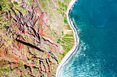 Cliffs overhanging green cultivated fields oceanfront, Fajas De Cabo Girao, Madeira island, Portugal
