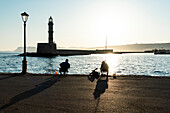 Fishermen in the old harbour of Chania at sunrise, island of Crete, Greece