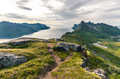Junge Wanderer mit Rucksack auf dem Weg vom Barden zum Segla Berg entlang des Fjords, Senja, Provinz Troms, Norwegen