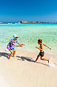 Cute little boy having fun with cheerful mother on the beach, Crete, Greece