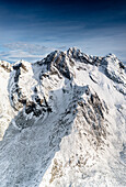 Rocky peak of Vetta di Rhon mountain covered with snow, aerial view, Rhaetian Alps, Sondrio, Lombardy, Italy