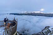 Zwei Personen fotografieren Berge unter dem nebligen Himmel vom Aussichtspunkt, Mannlichen, Jungfrau Region, Kanton Bern, Schweiz