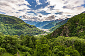 Bewölkter Himmel über dem grünen Wald, der Valchiavenna umgibt, Blick von Savogno, Provinz Sondrio, Valtellina, Lombardei, Italien