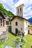 Traditional stone houses and church in the alpine village of Crana, Piuro, Valchiavenna, Valtellina, Sondrio, Lombardy, Italy