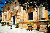 Schöne Frau bewundert die alte venezianische Fassade des heiligen Klosters Agia Triada Tzagarolon, Kreta, Griechenland