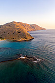 Aerial view of the small church of Agios Nikolaos on islet in the turquoise sea at dawn, Georgioupolis, Crete island, Greece