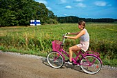 Fahrradfahren auf der Insel Nagu oder Nauvo in Väståboland in Pargas im südwestfinnischen Schärengarten von Turku. Die Schärenringstraße oder Saariston rengastie ist voll von Dingen, die man sehen, tun und unternehmen kann. Der Schärenweg kann im oder gegen den Uhrzeigersinn befahren werden. Er beginnt in der historischen Stadt Turku und führt durch ländliche Schärendörfer und erstaunliche Ostseelandschaften. Der Weg kann von Anfang Juni bis Ende August befahren werden.