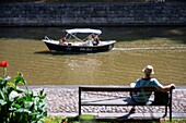 Familie in Elektrobooten, die auf dem Fluss Aura in Turku Finnland gemietet werden können.