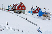 A stairway to colorful houses in a snowy landscape. Ilulissat, Greenland.
