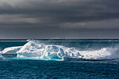 Wind blowing over the top of an iceberg. Disko Bay, Ilulissat, Greenland.