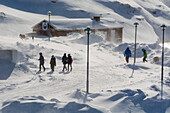 People walking in a street on a windy day. Ilulissat, Greenland.