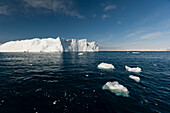 Ein Eisberg und Eisbrocken im Ilulissat-Eisfjord, einem UNESCO-Weltnaturerbe. Ilulissat-Eisfjord, Ilulissat, Grönland.