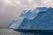 Ein Eisberg im Ilulissat-Eisfjord, einer UNESCO-Welterbestätte, an einem bewölkten Tag. Ilulissat-Eisfjord, Ilulissat, Grönland.