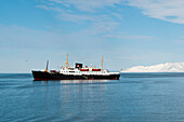 An expedition cruise ship anchored in Bockfjord's arctic waters. Bockfjorden, Spitsbergen Island, Svalbard, Norway.