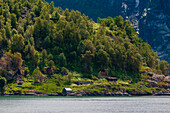 Primitive Bauernhäuser, die in die steilen, zerklüfteten Berge über dem Geirangerfjord gebaut wurden. Geiranger, Geirangerfjord, Norwegen.