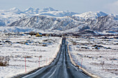 Die Nationale Touristenstraße, Lofoten, durch eine schneebedeckte und bergige Landschaft. Vestvagoy, Lofoten-Inseln, Nordland, Norwegen.