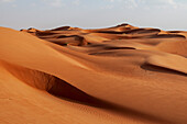 Eine Wüstenlandschaft mit vom Wind geformten und gekräuselten Sanddünen. Wahiba Sands, Oman.