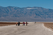 Touristen wandern auf den Salzpfannen in Badwater Basin. Death-Valley-Nationalpark, Kalifornien, USA.