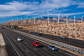 Der Verkehr passiert einen Windpark am San-Gorgonio-Pass in der Nähe von Palm Springs. San-Gorgonio-Pass, San-Jacinto-Berge, Riverside County, Kalifornien, USA.