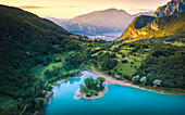 Sonnenaufgang im Tenno-See mit Riva del Garda und dem Berg Baldo im Hintergrund. Tenno, Trentino Südtirol, Italien