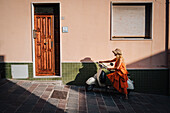 Ein Mädchen fährt auf einer Vespa in Sant'Antioco, Sulcis Iglesiente, Sardinien, Italien